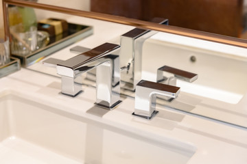 Modern bathroom with white washbasin with chrome faucet