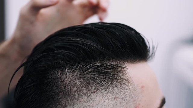 attractive man getting his hair slyled and blow dried after a haircut