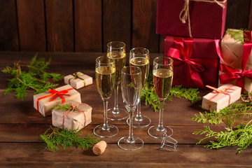 Christmas holiday table with glasses and a bottle of wine of champagne. Eve of new year, preparation and laying of a wooden holiday table