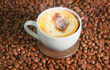 Coffee cup and coffee beans on wood table..