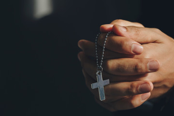Close up hands holding Cross necklace.Pray for god blessing to wishing have a better life.praying...