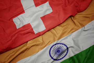 waving colorful flag of india and national flag of switzerland.