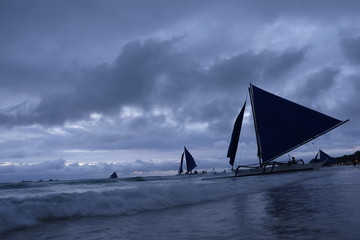 Fototapeta na wymiar stormy cloudy sky. Yachts on perspective ocean waves. Low angle. In Boracay Island Philippines