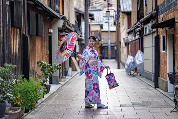 Fototapeta na wymiar Women Floral Printed Long Kimono in Gion House is an old wooden, traditional style at Gion Shijo Kyoto Japan.