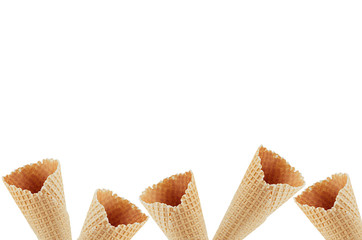 Summer food decorative border of empty waffle ice cream cones isolated on white background, copy...