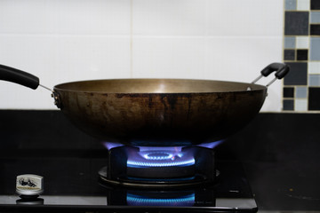 Gas stove burner with blue flames and dark background.