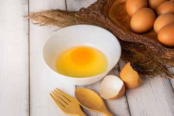 Fresh chicken eggs on white wooden table background.