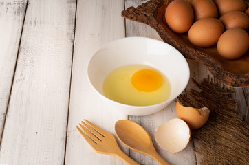 Fresh chicken eggs on white wooden table background.