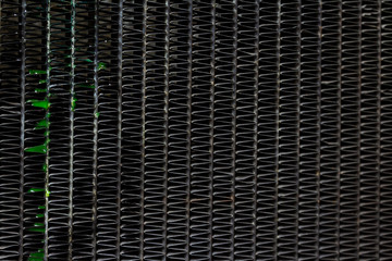Close up textured and fins with group of fresh green coolant liquid leaked out of the old aluminum car radiator waiting for repair background. Selective focus and copy space.