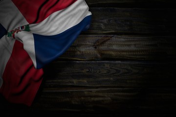 Fototapeta na wymiar wonderful dark photo of Dominican Republic flag with big folds on old wood with empty place for content - any occasion flag 3d illustration..