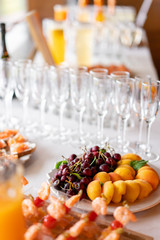 Fresh Fruit platter buffet at business or wedding event venue. Self service or all you can eat - cherries, nectarine, grapes and pineapple. Table with cold drink and snacks and tableware