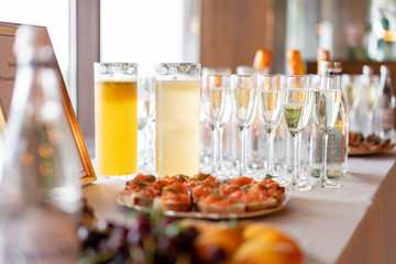 Glass bank of lemonade with sliced citrus fruits on a buffet table. Summer party outdoor. Detox.