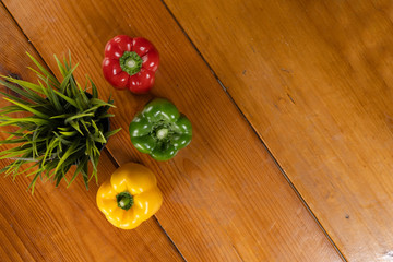 capsicum flat-lay at brown wooden background