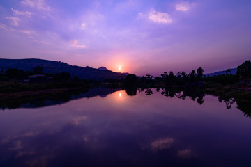 Sunset over a lake with calm waters reflecting sky