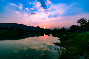 Fototapeta na wymiar Sunset over a lake with calm waters reflecting sky