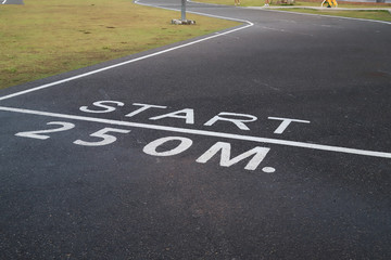 Closeup of starting point sign of running track after raining.