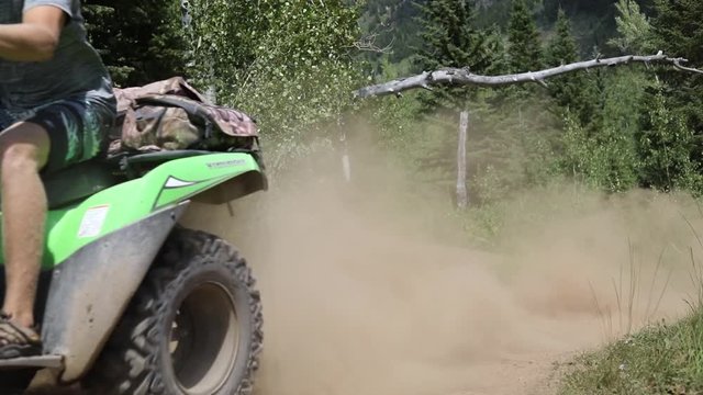 Slow motion shot of an ATV Rider driving his quad off of a small jump and getting a little bit of air time.