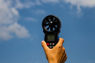 Man measuring wind speed with Digital Anemometer.