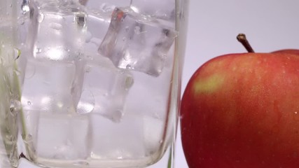 Juice dripping flowing on ice cube in glass red green apple orange - Powered by Adobe