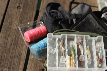 fishing paraphernalia sitting on the jetty. ie. fishing lines, floats, bait and tools, on a sunny afternoon, Victoria, Australia