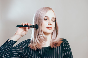 Fototapeta premium Portrait of a young pretty woman with make-up brush