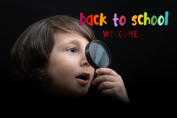 Portrat of a young boy looking through the magnifying glass