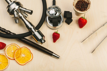 Parts of hookah and fruits on wooden background