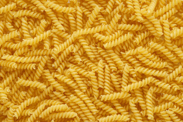 Dry uncooked girandole pasta as a background.
