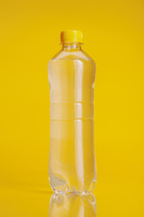 Plastic bottle of mineral water on a bright yellow background