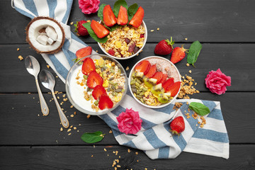 Home-made Yoghurt with granola, fruit and coconut top view on wooden background