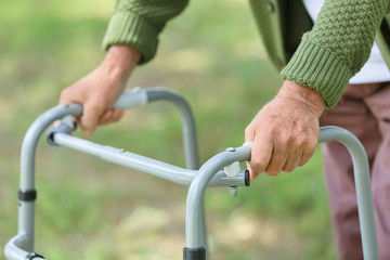Fototapeta na wymiar Elderly man with walking frame in park, closeup