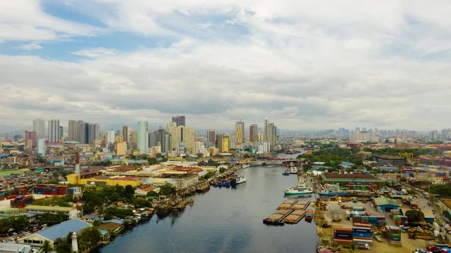 Time lapse of skyscrapers and business centers in a big city Manila under the blue sky and running clouds. Makati business center, aerial drone. Travel vacation concept.