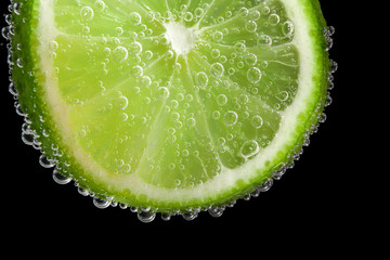Fototapeta na wymiar Ripe lime slice in water, closeup