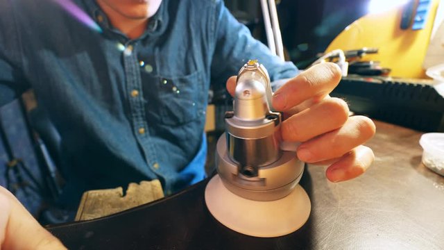 A gemstone is getting put into a ring by the goldsmith