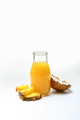 Bottle of fresh pineapple juice and coconut on white background