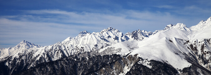 Panoramic view on snowy mountains in sun day