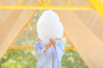 Woman with sweet cotton candy outdoors