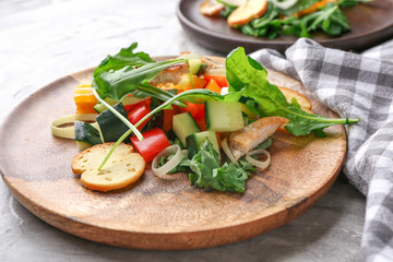 Plate with tasty arugula salad on grunge background