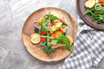 Plates with tasty arugula salad on grunge background