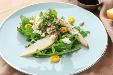 Plate with tasty arugula salad on table