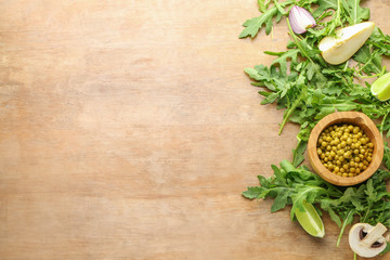 Fototapeta na wymiar Fresh arugula with peas in bowl on wooden background