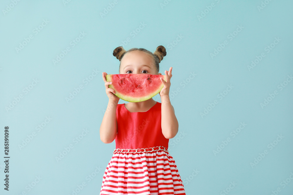 Wall mural cute little girl with slice of fresh watermelon on color background