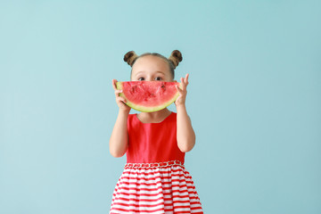 Cute little girl with slice of fresh watermelon on color background
