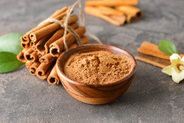 Aromatic cinnamon sticks and powder on grey background