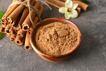 Aromatic cinnamon sticks and powder on grey background