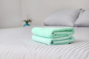 Obraz na płótnie Canvas Stack of clean towels on bed