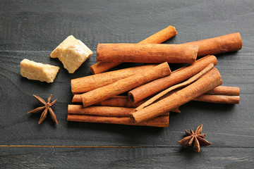 Aromatic cinnamon with sugar and anise on dark table