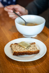 Close view of white plate with piece of bread and butter