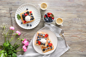 Tasty sweet waffles with coffee on wooden table