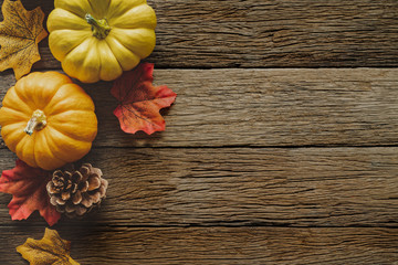 Autumn Thanksgiving day background from fallen leaves and fruits, pumpkin with vintage place setting on old wooden table. Thanksgiving day concept